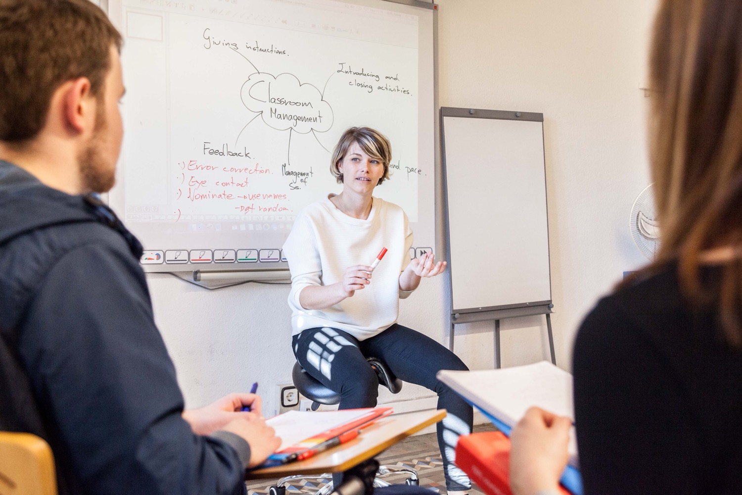 A teacher working with students on the course