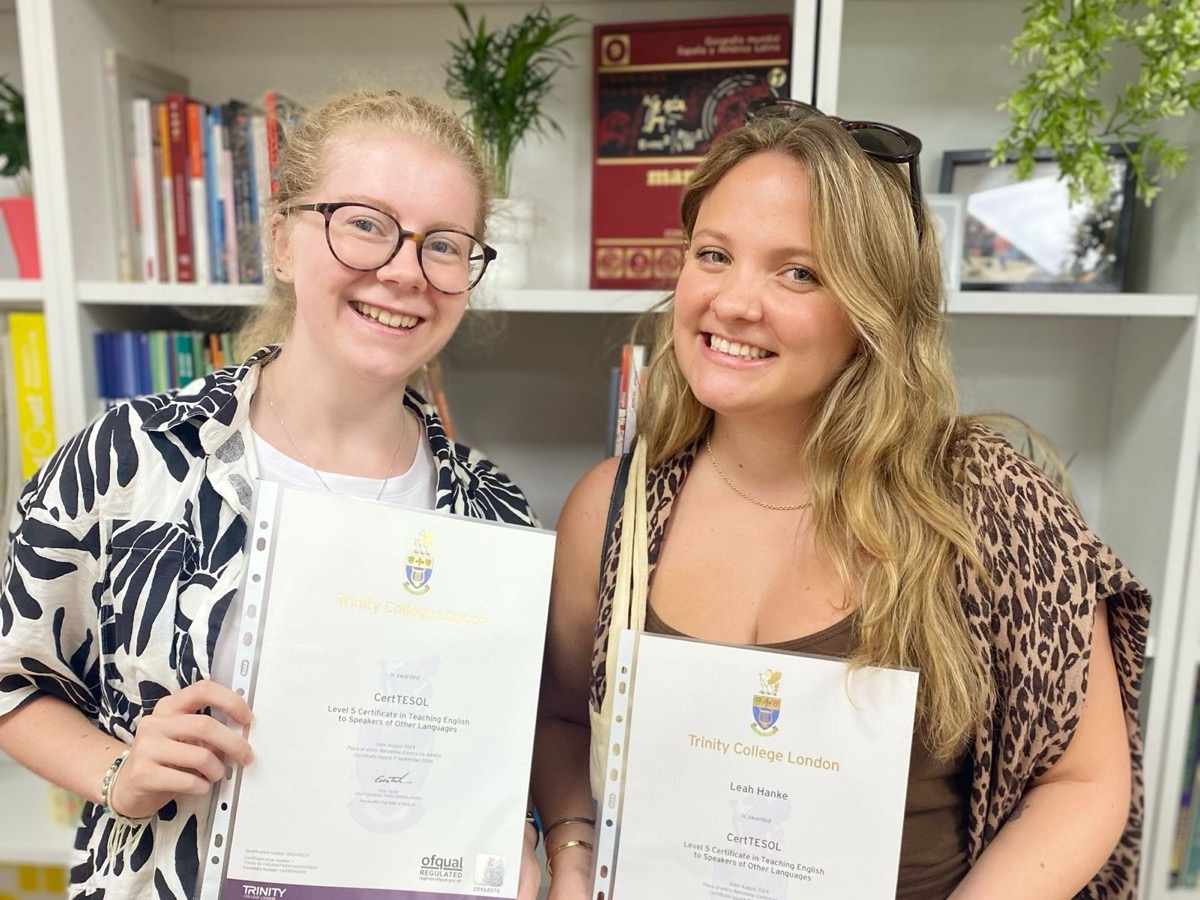 Two newly-qualified teachers holding their Trinity CertTESOL certificates